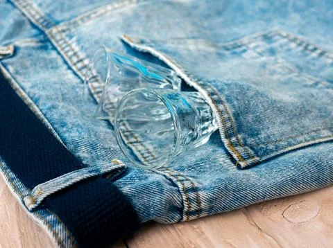 Top view Empty alcoholic glasses in denim pants. The concept of alcoholism... Stock Photos