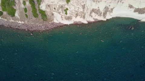 Top view of an empty and rocky coastline with cliffs and transparent waters Stock Footage 308362320