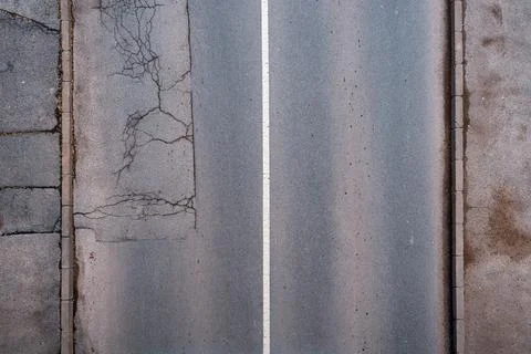 Top view of empty asphalt road with white center line, cracked pavement and.. Stock Photos