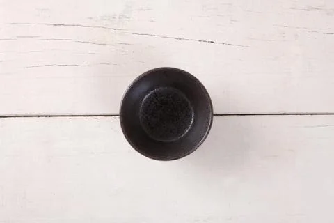 Top view of empty black plate put on white wood table with space for copy. Stock Photos