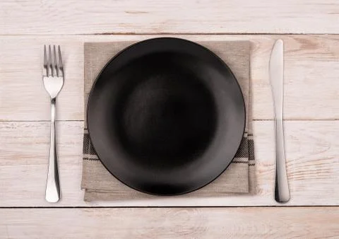 Top view of empty black  plate, silverware and napkin Stock Photos