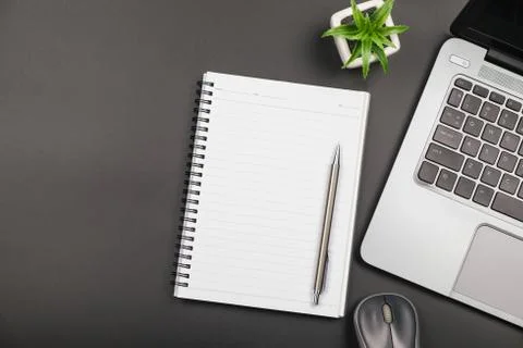 Top view of empty blank notebook with laptop on black background Stock Photos