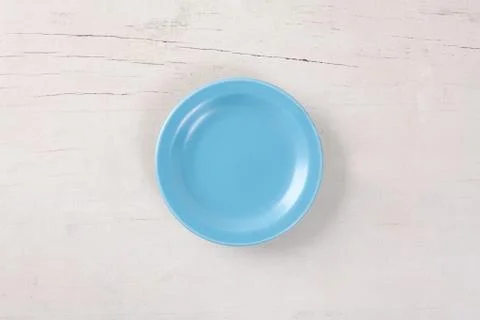 Top view of empty blue plate put on white wood table with space for copy. Stock Photos