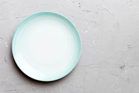 Top view of empty blue plate on cement background. Empty space for your desig Stock Photos