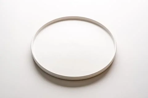 Top view of empty ceramic white plate on white background Stock Photos