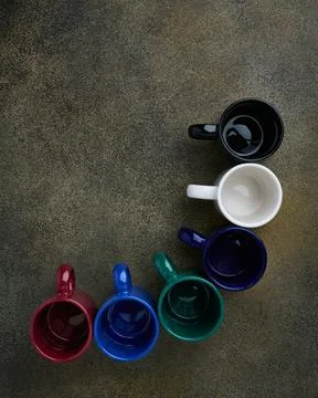 Top view of empty colored ceramic cups standing in an arc with space for text Stock Photos
