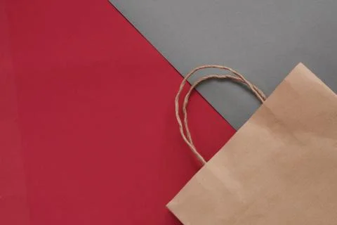 Top view of empty craft paper bag on a maroon background. Flat lay on maroon  Stock Photos