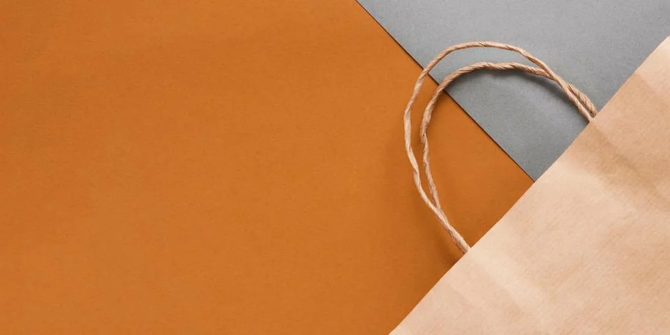 Top view of empty craft paper bag on maroon background. Flat lay on maroon ba Stock Photos