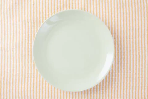 Top view of empty green plate put on cloth table with space for copy. Stock Photos