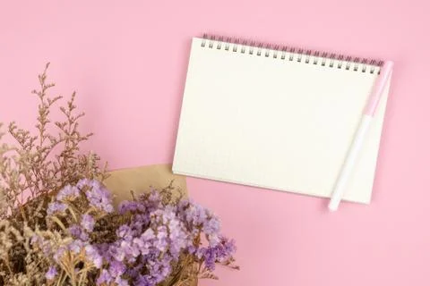 Top view of empty notebook and flower bouquet on pastel pink background Stock Photos