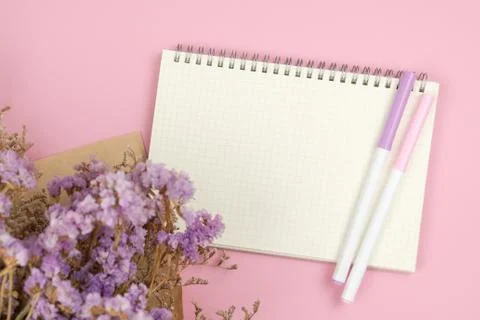 Top view of empty notebook and flower bouquet on pastel pink background Stock Photos