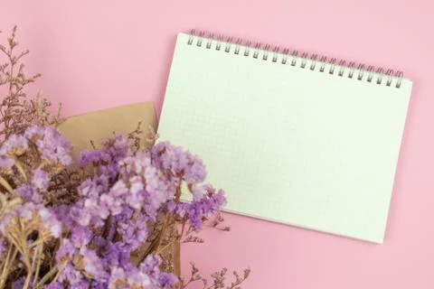 Top view of empty notebook and flower bouquet on pastel pink background Stock Photos