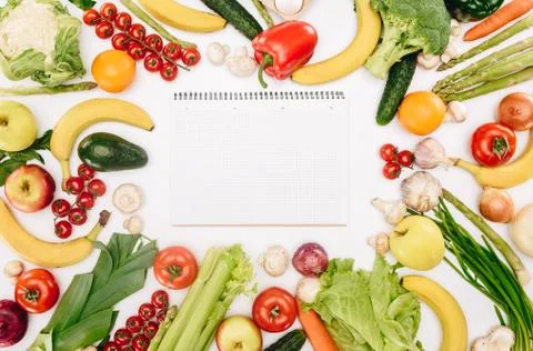 Top view of empty notebook between vegetables and fruits isolated on white, g Stock Photos