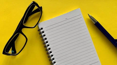 Top view of empty notebook with glasses and pen background. Business concept. Stock Photos