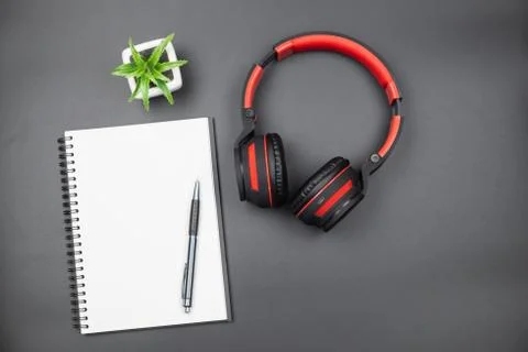 Top view of empty notebook with red headphone on black background Stock Photos