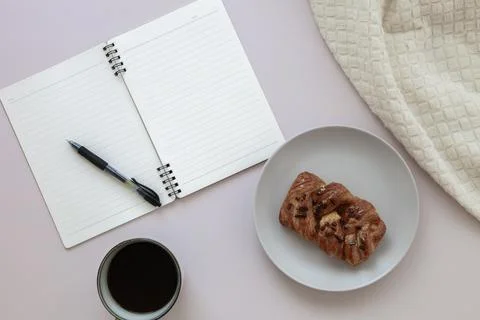 Top view of empty notepad with pen, cup of black coffee and pecan bun Stock Photos