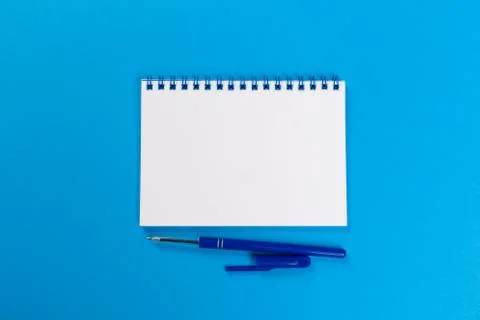 Top view of empty open notebook on blue background, office equipment, school  Stock Photos