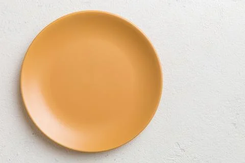Top view of empty orange plate on cement background. Empty space for your d.. Stock Photos