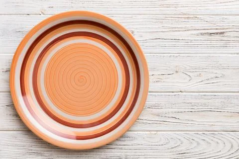 Top view of empty orange plate on wooden background. Empty space for your d.. Stock Photos