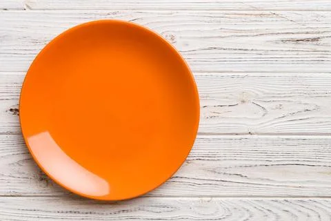 Top view of empty orange plate on wooden background. Empty space for your d.. Stock Photos