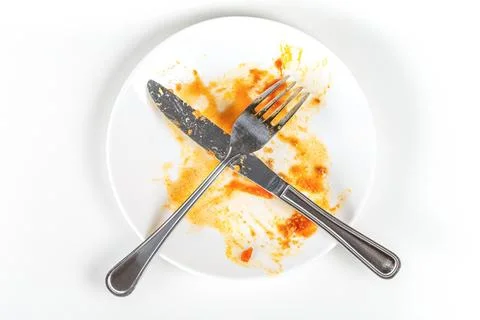 Top view of empty plate with fork and knife, dirty after the meal is finished Stock Photos