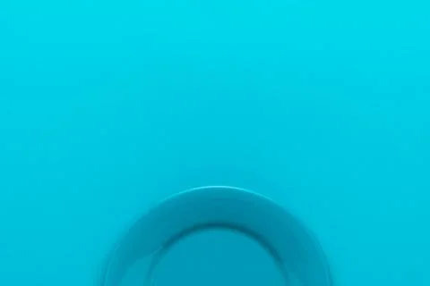 Top view of empty round blue plate on turquoise blue background with copy space Stock Photos