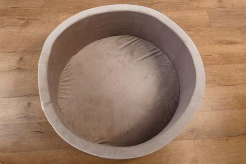 Top View of Empty Round Brown Soft Plush Pet Bed on Wooden Floor Stock Photos