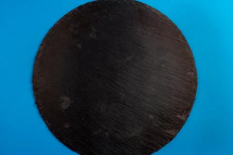 Top view of an empty round plate made of dark slate for serving cheese or mea Stock Photos