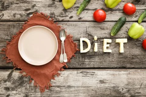 Top view empty serving plate, fork, spoon. Diet lettering, vegetebles, zucchi Stock Photos