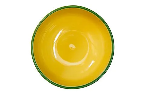 Top view of empty single yellow ceramic bowl with green edge. Stock Photos