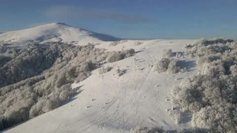 Top view of empty ski slopes. Drone flight above the snow-covered mountains Stock Footage 148245004