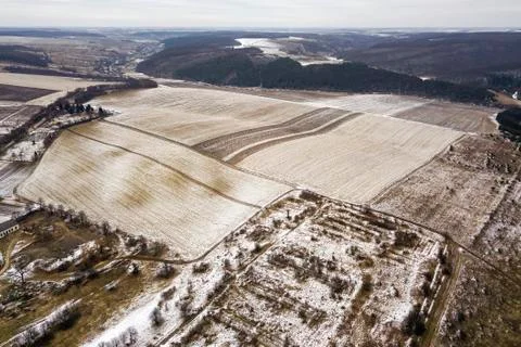 Top view of empty snowy fields and woody hills on cloudy sky background. Aeri Foto stock