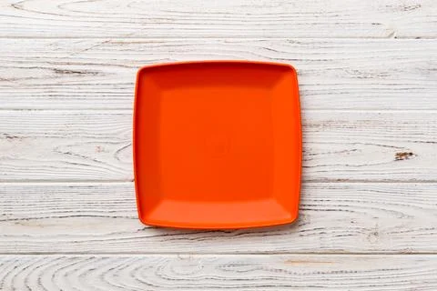 Top view of empty square plate on wooden background. Empty space for your d.. Stock Photos