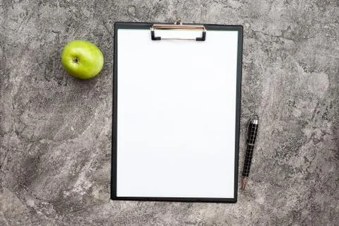 Top view empty white blank paper next a pencil and a fresh green apple on the Stock Photos