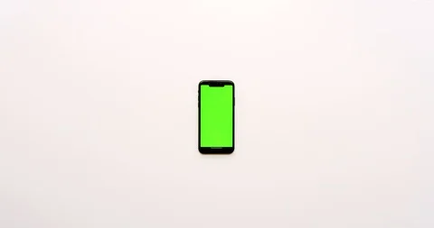 Top view on the empty white office table and black smartphone with green screen Stock Footage 85974678