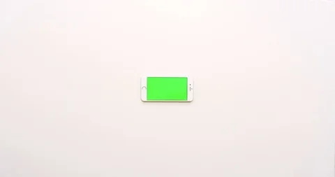 Top view on the empty white office table and white smartphone with green screen Stock Footage 85974698