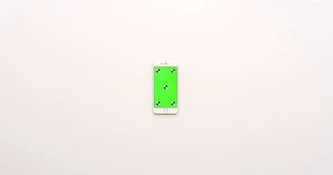 Top view on the empty white office table and white smartphone with green screen Stock Footage 85974867