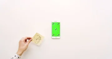 Top view on the empty white office table and white smartphone with green screen Stock Footage 85974917