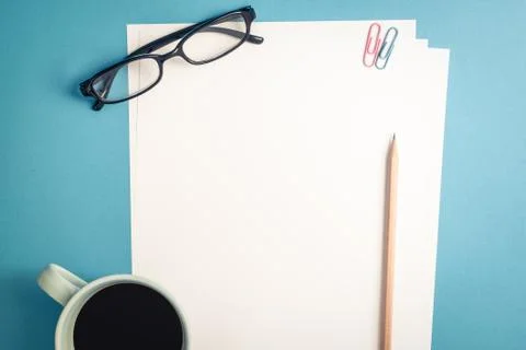 Top view of empty white paper on blue background Stock Photos