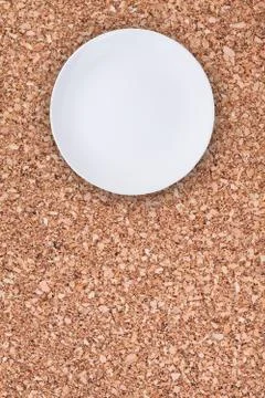 Top view of an empty white plate placed on cork background with copy space. Stock Photos