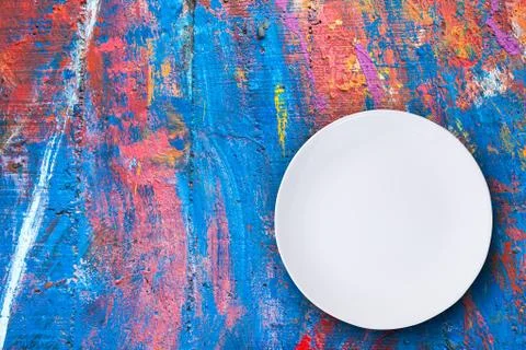 Top view of empty white plate put on colorful table with space for copy. Stock Photos