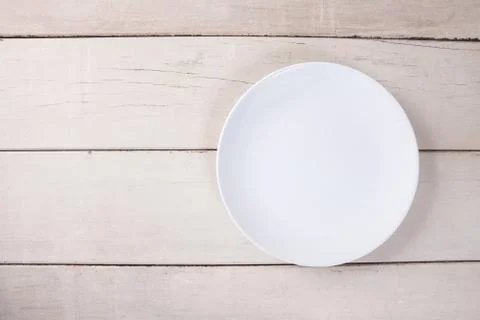 Top view of empty white plate put on white wood table with space for copy. Stock Photos