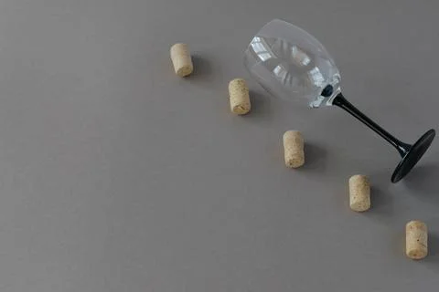 Top view of an empty wine glass with wine corks on a gray background with pla Stock Photos