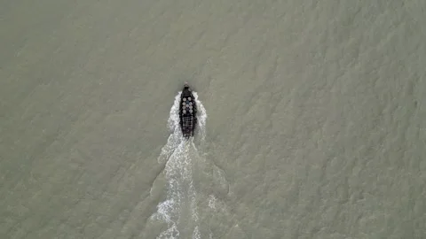 Top view of an engine-powered boat navigating through dirty, murky sea water. Video stock 287779862
