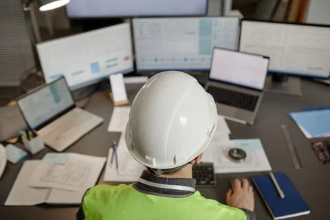 Top view of engineer wearing hardhat and using computer Stock Photos