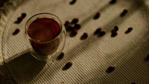 Top view of espresso in double-walled glass with scattered coffee beans Stock Footage 346302982