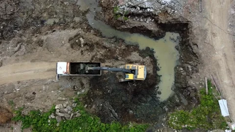 Top View of Excavator Loading Earth into Dump Truck at Construction Site Stock Footage 292521218