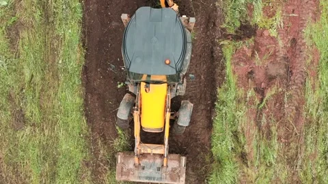 Top view of excavator working in field. Clip. Bulldozer clears plot of land with Stock Footage 145536084