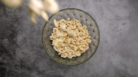 Top view falling cashew nuts into a bowl, Slow motion. Video stock 157411640