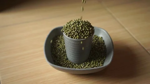 Top view of falling slowly mung beans into the cup and bowl. Stock Footage 250446432
